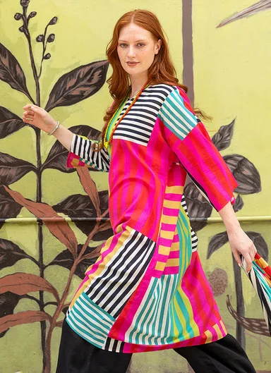 A woman wearing a colourful striped dress from Gudrun Sjödén.