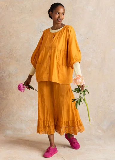 A woman wearing red woven clothes from Gudrun Sjödén.